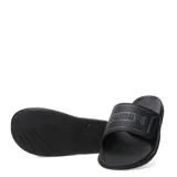 Sandalias Puma modelo Royalcat Comfort 2, color negro con detalles en gris. Presentan una banda superior ajustable con el logo de la marca en relieve y una plantilla ergonómica diseñada para mayor comodidad.
