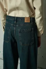 Jean de corte wide leg en color azul oscuro, con tiro medio y ruedo ancho con costura reforzada.
