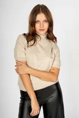 Sweater color beige de tejido de punto, con cuello alto y mangas cortas.