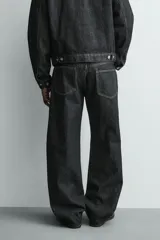 Pantalón jeans de corte recto y ajuste holgado, confeccionado en denim de algodón rígido. Presenta diseño clásico de cinco bolsillos, cierre frontal con cremallera y botón, con un acabado de lavado claro.