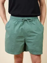 Short de algodón color negro con cintura elástica y cordón de ajuste. Presenta bolsillos laterales y un pequeño parche con logo en la parte inferior.