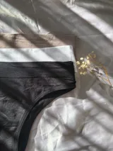 Pack de tres bombachas tipo bikini confeccionadas en tejido elástico, con diseño sin costuras en tonos negro, blanco y nude.