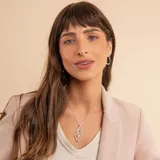Collar de plata 925 con cadena fina tipo veneciana y un dije colgante de diseño geométrico en forma de ojo o hoja estilizada, compuesto por dos siluetas entrelazadas, una de ellas con detalles de brillo.