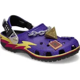 Zuecos Crocs Classic edición especial Yu-Gi-Oh!, de color morado con detalles gráficos de rayos en amarillo y fucsia, correa trasera ajustable y dijes Jibbitz temáticos que incluyen el Rompecabezas del Milenio y una carta de duelo.