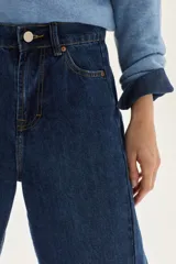 Jean de mujer color azul oscuro, tiro alto, con corte barrel y pierna ancha y ligeramente curva. Confeccionado en 100% algodón.