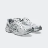 Championes Asics modelo Gel 1130, color blanco con detalles plateados y verde oscuro. Diseño retro inspirando en el running con tecnología GEL en el talón.