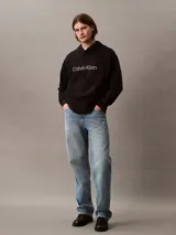 Buzo con capucha de Calvin Klein confeccionado en tejido de felpa de algodón. Presenta un diseño de corte relajado con bolsillo tipo canguro, puños y dobladillo acanalados, y el logo de la marca estampado en el frente.