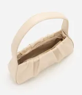 Cartera tipo baguette de marca Satinato, confeccionada en material sintético de poliuretano con textura crocco en color beige. Cuenta con diseño estructurado, cierre en cremallera con herrajes dorados y asa fija de hombro.