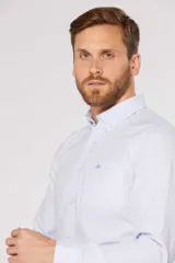 Camisa de manga larga con diseño de rayas finas, cuello con botones, cierre frontal abotonado y bolsillo en el pecho con logo bordado.
