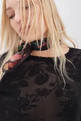 Sweater de calce relajado con diseño jacquard floral y destellos de lurex. Presenta cuello redondo en rib, mangas largas y puños con terminación en punto festón.