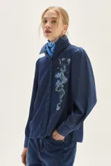 Camisa de lyocell azul oscuro con bordado floral a tono en el pecho y mangas voluminosas. Presenta un calce recto.