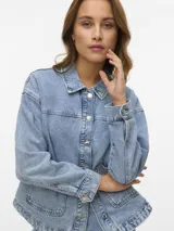 Campera de denim azul oscuro con cierre frontal de botones metálicos, bolsillos frontales aplicados y cuello camisero, de corte recto y holgado.