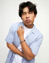 Pulsera Uno de 50 con cordones de cuero negro, pieza central bañada en plata con cristal facetado color gris y cierre de nudo corredizo con cuentas plateadas.