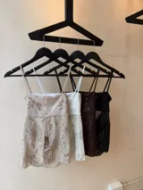 Top de tul color champagne con bordado de lentejuelas y diseño floral, tirantes finos, escote recto y abertura frontal pronunciada.