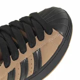 Championes Adidas Superstar ST, color marrón tostado con detalles en negro. Presentan el diseño icónico de la puntera de goma, tres tiras laterales en negro y suela de goma resistente.