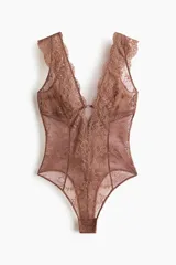 Body de encaje color marrón, con escote en V pronunciado y breteles anchos con detalle de encaje festoneado. Presenta copas sin forro ni aros y un refuerzo interior con botones a presión ocultos en la parte inferior.