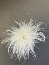 Broche decorativo compuesto por plumas de avestruz en color turquesa, con un diseño circular voluminoso.