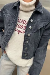 Campera de jean con efecto lavado ácido en color negro, de corte vintage, con costuras reforzadas en hilo color maíz y botones metálicos frontales.