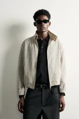 Cazadora cropped fit para hombre con estampado a cuadros, cuello subido, cierre frontal con cremallera y bolsillos con solapa en la cadera.