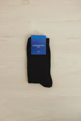 Par de medias de vestir, color negro, de largo medio, con textura acanalada.