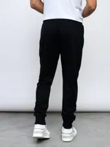 Pantalón de jogging gris melange con puños ajustados en los tobillos y cordón en la cintura. Presenta el logo Umbro bordado en negro en la pierna izquierda.