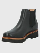 Botin tipo Chelsea de cuero negro con paneles laterales elásticos y detalle de textura en el talón. Cuenta con una suela de plataforma dentada en color negro con una franja intermedia en tono madera.