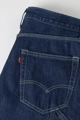 Jeans de denim azul oscuro con corte holgado y recto, estilo carpintero, con trabillas para cinturón y bolsillos funcionales.