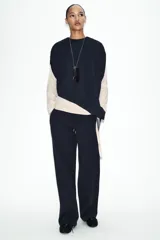Pantalón de tiro medio confeccionado en tejido de punto elástico con pierna recta. Cuenta con cintura elástica ajustable mediante cordones y bolsillos laterales.
