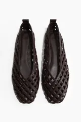 Ballerinas marrones con diseño trenzado y punta redonda, elaboradas con tiras entrelazadas que forman un patrón geométrico tipo red.