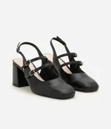Zapato estilo Mary Jane de color negro, confeccionado en poliuretano con diseño cerrado y puntera cuadrada. Presenta tres tiras cruzadas en el empeine con hebillas metálicas ajustables, tira trasera con hebilla y taco bloque ancho.