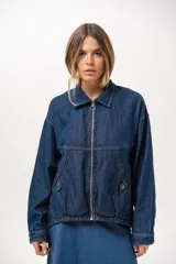 Campera de jean azul de silueta relajada, con cuello clásico, cierre frontal con cremallera metálica y bolsillos laterales.