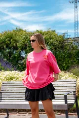 Remerón oversize color fucsia con estampado de dos manos formando un corazón en el pecho y la frase "conecta contigo primero".