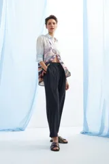 Pantalón de vestir azul marino, de corte recto, con bolsillos laterales y traseros. Se ajusta a la cintura con cinturón de cuero marrón.