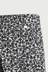 Short de baño largo con estampado geométrico en tonos oscuros sobre fondo claro, cintura elástica ajustable con cordón y bolsillos laterales.