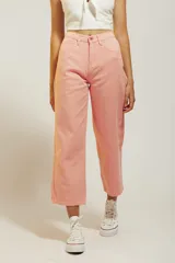Pantalón de jean color amarillo pastel, de corte recto y tiro medio, con diseño de cinco bolsillos y cierre frontal con botón y cremallera.