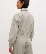 Campera deportiva de corte oversized, confeccionada en poliamida con tecnología dry. Presenta cuello camisero estructurado, cierre frontal con cremallera, bolsillos laterales, puños elásticos y ruedo con ajuste elástico.