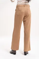 Pantalón de corte recto y tiro alto, confeccionado en material símil gamuza con textura suave.