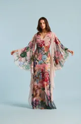 Vestido largo con estampado floral multicolor, escote en V y mangas amplias tipo capa.
