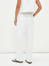 Pantalón de vestir blanco, de tiro alto y corte palazzo, con bolsillos laterales y bolsillos cargo con solapa en los muslos.