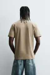 Camiseta slim fit de manga corta y cuello redondo, confeccionada en tejido de algodón con elasticidad.