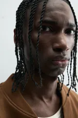 Cazadora bomber negra de corte regular fit, confeccionada en tejido efecto ante. Cuenta con cuello, puños y bajo en rib elástico, manga larga, bolsillos de vivo en la cadera y un bolsillo interior. Cierre frontal con cremallera.