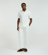 Camisa de manga corta color blanco con diseño bordado de flores, cuello inglés y cierre frontal de botones.