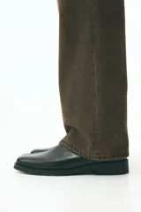 Jeans de cinco bolsillos en denim de algodón rígido, color marrón oscuro con efecto lavado. Modelo de cintura estándar con cierre y corte relajado, pierna recta y amplia desde el muslo.