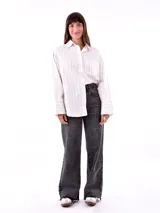 Camisa blanca con rayas verticales finas color beige, de corte amplio y mangas largas con puños abotonados.