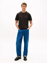 Remera de corte slim color negro con mangas cortas, cuello redondo y detalle de doble raya blanca en los puños. Presenta el icónico logo bordado de la marca en el pecho.