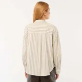 Camisa de popelina de manga larga con diseño a rayas verticales en tonos beige, blanco y azul, cuello camisero y cierre frontal de botones.