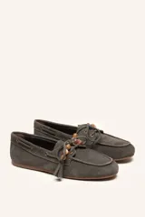 Mocasín estilo náutico de gamuza marrón, con cordones de cuero, borla decorativa y cuentas de colores en el empeine.