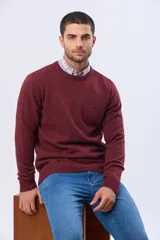 Buzo tejido de lana con escote redondo a la base, de manga larga y calce clásico.