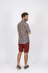 Camisa de manga corta con estampado de cuadros en tonos azul, rojo y beige, confeccionada en algodón. Presenta cuello clásico y cierre frontal con botones.