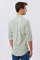 Camisa de lino y algodón color blanco, con cuello mao, manga larga y cierre frontal de botones. Presenta un pequeño logo bordado en el pecho.